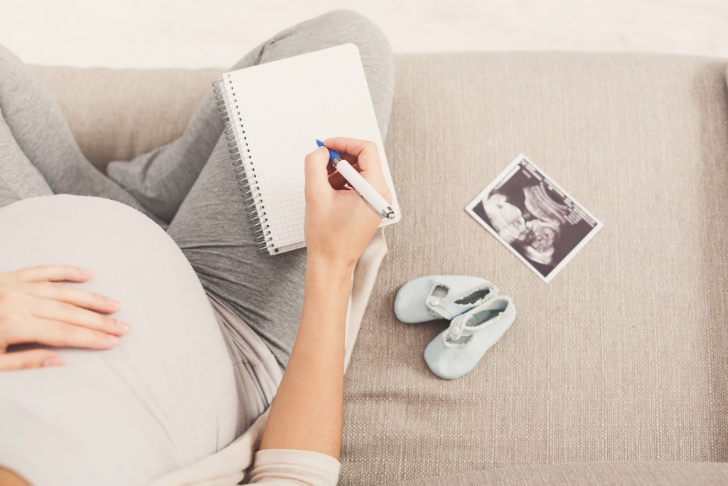 Une femme enceinte dresse la liste de tout ce qu'elle doit faire avant l'arrivée de son bébé.