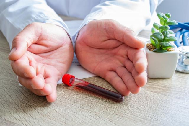 Un médecin a une fiole de sang entre les mains