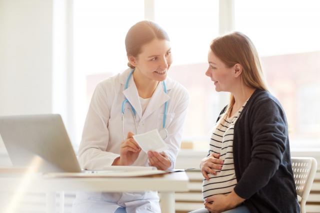 Une femme médecin discute avec une patiente enceinte