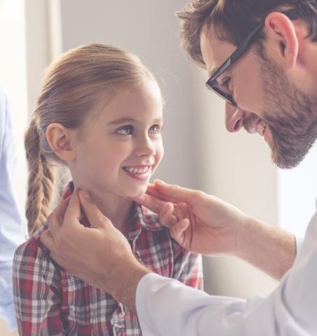 Un médecin touche les ganglions d'une jeune patiente.