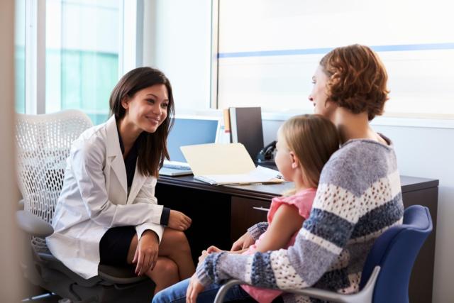 Une médecin de famille lors d'une consultation avec une mère et son enfant